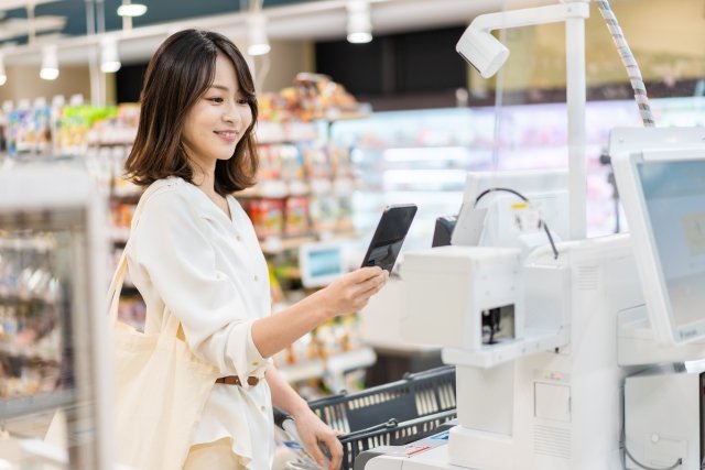 セルフレジ　電子マネー決済をする女性.jpg